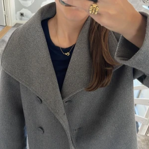 Grå Gina Tricot kappa - Säljer en jättefin grå kappa från Gina Young, då den är lite stor på mig🍂🩷Perfekt nu till hösten och även våren! Köpt förra hösten och inte använd särskilt mycket så den är i superbra skick! För egna bilder eller frågor är det bara att skriva🩷! Nypris 400