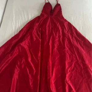 Balklänning/festklänning  - En jätte fin och lång röd klänning. Använd endast en gång. Storleken är M/L