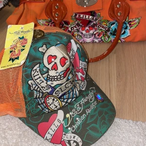 Äkta ed Hardy keps - Rare kamouflage ed Hardy keps (med Christian audigier) korallorange och kamo:) felfrit skick, endast lappen som är lite snead🔥 kan köpas i sett med ed Hardy väska men kom privat innan för info o pris då! 