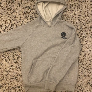 Basic grå hoodie - En snygg, basic grå hoodie med en svart ris på framsidan. Otroligt skön och bra passform, säljer för att jag har växt ur den. Köp gärna🔥