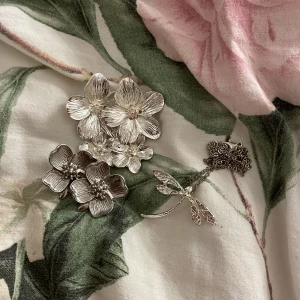 Silver smycken  - 2 par blom örhängen och ett trollsländehalsband i silver (inte äkta silver), kedjan är lite lätt rostig men inget som syns när den används!🩷