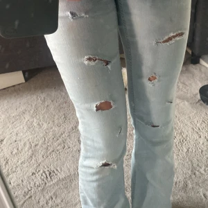 Ljusa slitna jeans - Säljer ett par ljusa jeans med slitningar för en cool och avslappnad look. De är mid waist och har en straight passform som är både bekväm och trendig. Perfekta för vardagsbruk eller en avslappnad utekväll! Innerbens längden är 68 och midjemåttet är 32❤️