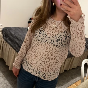 Vit spetsblus - Säljer en superfin vit spetsblus med långa ärmar. Perfekt för både vardag och fest! Blusen har ett vackert mönster och är lätt att matcha med jeans eller kjol. Den är i mycket bra skick och känns både elegant och bekväm.