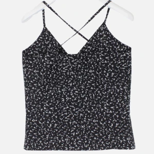 Svart och vit mönstrad linnetopp från Gant - Snygg svart och vit mönstrad linnetopp från Gant med smala axelband som korsas i ryggen. Perfekt för sommardagar eller en avslappnad kväll. Toppen har en bekväm passform och är tillverkad i ett lätt material. Säljs i storlek 40 i jättebra skick då den endast används fåtal gånger 🥰