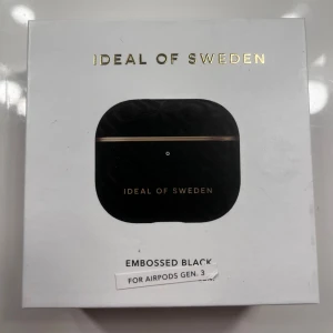 Embossed Black AirPods-fodral från iDeal of Sweden - Snyggt och stilrent AirPods-fodral i svart med präglat mönster från iDeal of Sweden. Passar AirPods Gen. 3 och har en elegant gulddetalj. Helt oanvänd och oöppnad!