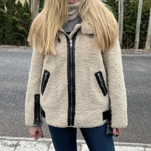 Beige teddyjacka från ZARA - Säljer en supermysig och cool beige teddyjacka från ZARA. Den har en dragkedja framtill och coola svarta detaljer vid fickorna. Perfekt för höst och vinter! Passar perfekt till både vardag och lite finare tillfällen. Första bilden är lånad🩷