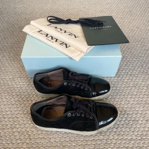 Lanvin patent cap toe sneaker black - Lanvin patent cap toe sneaker black, bra skick men har synliga täcken på användning t.ex sulan, allt originellt medföljs vilket är två dust bags, extra snören, boxen och även kvittot om det önskas. Storlek UK9 - EU43. Byte öppet.