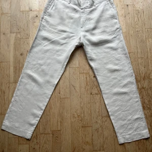 Vita linnebyxor från H&M - Säljer ett par vita linnebyxor i bra skick. De är perfekta för sommaren med sin lätta och luftiga känsla. Byxorna har en normal passform. De har en enkel design med dragkedja och knapp framtill. Perfekta för en laid-back och stilren look!