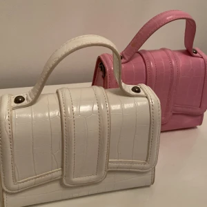 Axelväskor från  Zara🩷 - Säljer två snygga axel/hand väskor från Zara med axelband🩷 En är vit och den andra är rosa. Båda är i bra skick/använda få gånger🩷(väskorna är i styckpris)