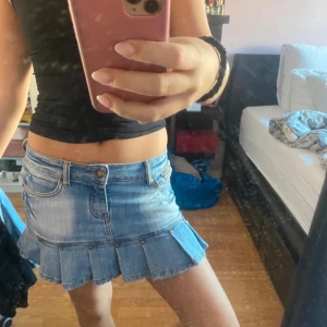 Jeanskjol med volang  - Säljer en superfin jeanskjol i ljusblå denim. Kjolen har en kort längd med volangdetaljer. Passar perfekt med en enkel topp eller en snygg blus!