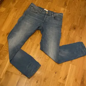 Säljer ett par snygga blå jeans från Jack & Jones i modellen Slim Straight/Tim. Helt nya, tvättade och använda en gång.  Perfekt passform åt det mera slim hållet