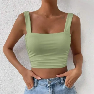 Grön croppad linnetopp - Snygg och stilren grön croppad linnetopp perfekt för sommardagar. Toppen har breda axelband och en fyrkantig halsringning som ger en modern look. Materialet är mjukt och stretchigt för en bekväm passform. Passar perfekt till jeans eller kjol för en avslappnad stil.