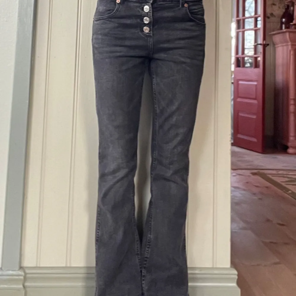 Säljer ett par snygga svarta bootcut jeans från Zara i storlek 13-14 år. De har en låg-mellan midja och knappar framtill. Perfekta för både vardag och fest! 🖤. Jeans & Byxor.