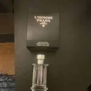 Säljer en elegant L'Homme Prada Eau de Toilette, 35-40ml. Flaskan är stilren och genomskinlig med en silverfärgad kork. Doften är perfekt för den moderna mannen som vill ha en sofistikerad och fräsch känsla. Kommer med originalförpackning.