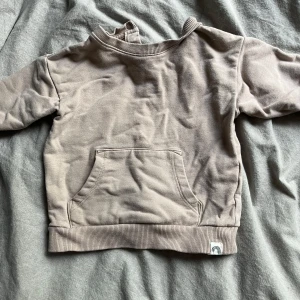Beige babytröja från Lindex - Säljer en söt och bekväm beige babytröja från Lindex. Tröjan har långa ärmar och en praktisk magficka. Perfekt för höst och vår. Den är i mycket bra skick och redo för en ny liten ägare!