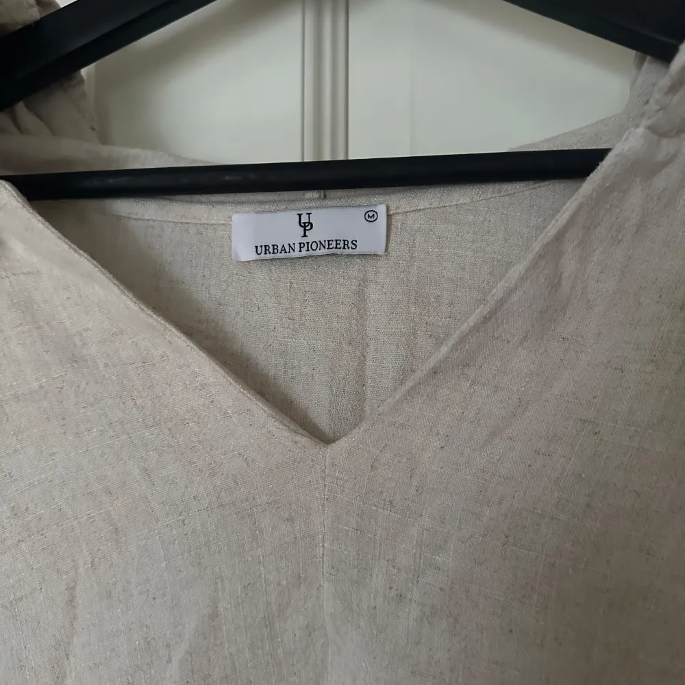 Säljer en superfin beige tröja från Urban Pioneers. Den har en avslappnad passform med långa ärmar och detaljer på ärmarna och luvan. Behövs strykas. Använd enstaka gång. Katt finns i hemmet. . Neuletakit & Villapaidat.