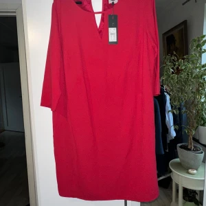 Röd klänning från Street One - Säljer en snygg röd klänning från Street One i storlek 40. Klänningen har en enkel och stilren design med trekvartsärmar och en v-ringad hals. Perfekt för både vardag och festliga tillfällen. Ny med taggar kvar!