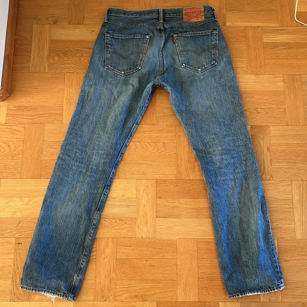 Säljer ett par klassiska blå Levi's jeans i bra skick. De har en straight/slim passform med riktigt snygga slitningar och hål, som gör att byxorna sticker ut. Hör av er vid frågor eller funderingar!. Jeans & Byxor.