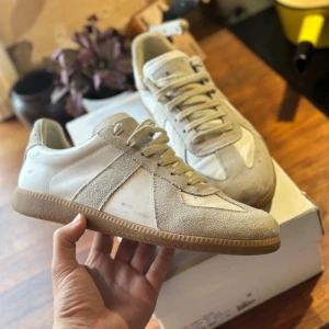 Maison margiela gats - Tjena! Nu säljer jag dessa riktigt feta Maison margiela gats skorna i beige och vitt. De har en klassisk design med grunder från tyska militär skor. Dem är i bra skick, avgör själv exakta skicket med bilderna. Boxen och dam skydd tillkommer men boxen är tyvärr (lite) söndrig/ skadad, men inget som spelar roll om du inte ska gå runt med boxen. OBS dem är INTE äkta :)) finns inga dåliga frågor såklart! MVH Abbe, kan som med alla andra produkter jag säljer gå ner i pris vid en SNABB affär!