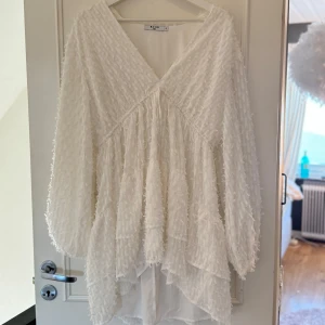 Vit student/sommarklänning - Superfin vit klänning i ett fluffigt material. Den har en v-ringad design och långa ärmar, perfekt för vår, sommar eller student! Klänningen har en lös passform och volangdetaljer🤍 Använd få gånger🩷