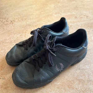 Fred perry Lädersneakers svarta herrskor märkesskor - Välbevarade lädersneakers från Fred Perry i all black. Storlek 43 modell B8146/951, 10000/283 Nypris 1399 kr, mitt pris 349 kr  Kan hämtas i Bromma eller skickas med spårbar post. Kan även samskickas med mina andra annonser.