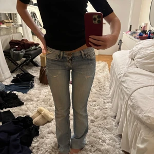Ljusblå jeans - Säljer ett par ljusblå jeans i bra skick, de har slitningar då de är vintage och det finns en liten slitning/hål vid ena bakbyxfickan, kan skicka bild på den privat. De är lågmidjade och har en bootcut-stil. Perfekta för både vardag och fest!🩷 skulle uppskatta storleken till en XS/W25! Står ingen storlek inuti tyvärr