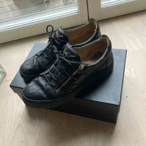 Giuseppe zanotti skor  - Säljer ett par svarta sneakers i skinn med coolt rutmönster. De har både snörning och dragkedja för en unik look. Skorna är i bra skick. Perfekta för höst och vår. Pris kan diskuteras vid snabb affär. Box följer med