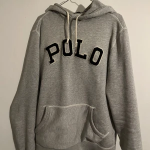 Grå hoodie från Polo Ralph Lauren - Säljer en snygg grå hoodie från Polo Ralph Lauren i storlek S men sitter som M/L. Nypris ungefär 2200. Väl använd men har varit omhändertagen bra.Hör av dig vid frågor/funderingar