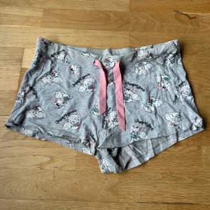 Ett par grå shorts från Cubus i storlek XS. De har ett gulligt kattmotiv med texten 'Purrfect Friends' och rosa detaljer. Shortsen är gjorda av bomull och polyester, vilket gör dem supersköna. De har använts så har lite noppor 🐱💖