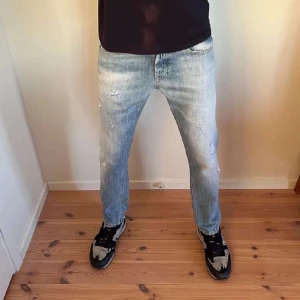 Dondup - Säljer ett par ljusblå jeans i bra skick med snygga slitningar för en cool look. De har en normal passform och är perfekta för vardagsbruk. Jeansen har en klassisk femficksdesign och är tillverkade i slitstarkt denim. Perfekta för både höst och vår! Nypris: 3299kr storlek 30🙌🏾hör av er vid funderingar 