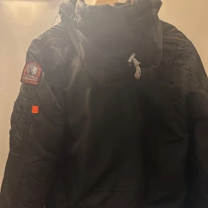 PJS vinterjacka - Säljer en svart Pjs vinterjacka i mycket bra skick. Eftersom fick den förra året som present men inte har använd den . Har inga smuts eller skador. Väldigt varm och skönt, med en stor luva.  Den har flera  fickor och en dragkedja framtill. Perfekt för kalla vinterdagar! 🖤
