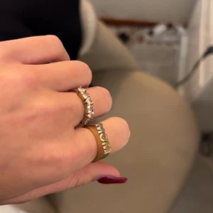 Guldfärgad ring med texten 'MOM' - Säljer en snygg guldfärgad ring med texten MOM men kan även has som WOW. Tyvärr kommer den inte till användning längre ❤️ strl 16,8mm