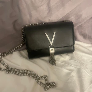 Svart axelväska från Valentino - Snygg svart axelväska från Valentino i skinn. Den är i mycket bra skick den ända skavankern är att den har lite rost under smycket på framsidan men är ingenting som syns när man har den på sig. Pris kan diskuteras💕