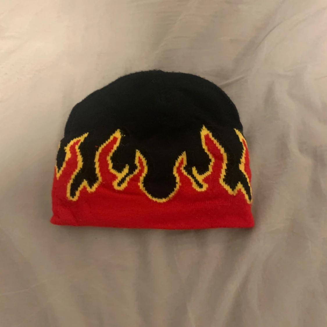 Svart och röd mössa med flammor