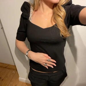 Svart topp från H&M - Snygg svart topp från H&M i storlek S. Den har korta ärmar som ger en elegant touch. Perfekt för både vardag och festliga tillfällen. Toppen är i bra skick och passar utmärkt till både jeans och kjol.