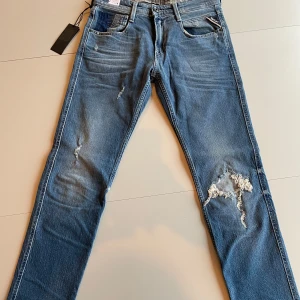 Helt nya replay anbass jeans - Säljer ett par snygga Replay anbass jeans med slitningar. Jeansen är HELT NYA och aldrig använda med tags kvar                                                                     Priset kan diskuteras