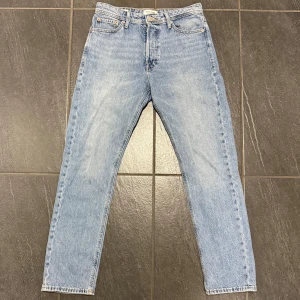Ljusblå jeansbyxor - Säljer ett par ljusblå jeans i loose fit från Jack & Jones. De har en klassisk femficksdesign och är perfekta för en avslappnad stil. Passar bra till både vardag och fest. Byxorna är i bra skick och redo för en ny ägare!