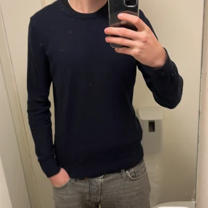 Mörkblå tröja från J.Lindeberg - Säljer en stilren mörkblå tröja från J.Lindeberg i storlek S. Tröjan har en klassisk rund hals och är perfekt för både vardag och fest. Den är i mycket bra skick och passar bra till jeans eller chinos. Perfekt nu inför hösten. Hör av er vid minsta fundering😊