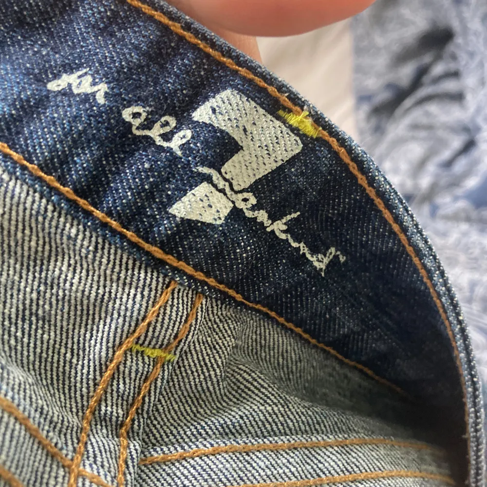 Säljer ett par snygga blå jeans från 7 for All Mankind. De har en bootcut-stil och är i mycket bra skick. Perfekta! Säljer då de blivit försmå har en liten defekt på knät, en fläck men inget man tänker på! Fråga om de är något!🧡 passar mig som 165 ish och oftast har 27/28 i midjan så skulle mer säga 26 . Jeans & Byxor.