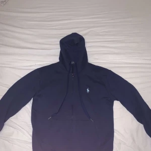 Mörkblå hoodie från Polo Ralph Lauren - Säljer en mörkblå hoodie från Polo Ralph Lauren i nytt skick, med en skön passform och huva. Storlek:S/M