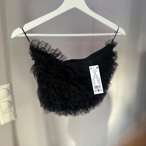 Svart volangtopp Gina Tricot - Superfin svart topp med volanger. Aldrig använd med lappar kvar. Perfekt för fest eller en utekväll. 