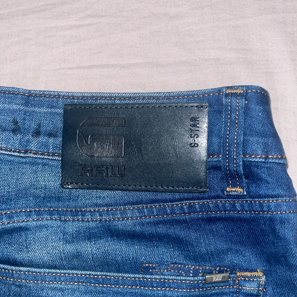 Säljer ett par snygga blå jeans från G-Star RAW, modell 3301 Straight. De har en klassisk rak passform och är i bra skick. Perfekta för både vardag och fest! Har tyvärr inte kvittot. Dom är använda men bra form. Det här är en gammal model så svår att hitta. Pris kan diskuteras.. Jeans & Byxor.