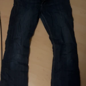 Lågmidjade jeans - Säljer ett par mörkblå bootcut jeans från &Loyal i storlek 29x32. De har en klassisk femficksdesign och är perfekta för en avslappnad stil. Passar både till vardags och fest. Skicket är bra och de är bekväma att bära. Perfekt för dig som gillar en tidlös look!