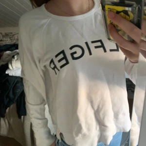 Vit långärmad tröja från Tommy Hilfiger - Säljer en snygg vit långärmad tröja från Tommy Hilfiger. Tröjan är i bra skick och har en normal passform. Perfekt för både vardag och avslappnade tillfällen. Den är gjord av bomull och har en enkel men stilren design med Hilfiger-loggan på bröstet. Passar perfekt till jeans eller leggings!