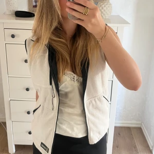 Beige fleeceväst  - Säljer en supermysig beige fleeceväst med svarta detaljer. Västen är i storlek M och passar perfekt nu när hösten närmar sig. Fint sick utan synliga defekter. 