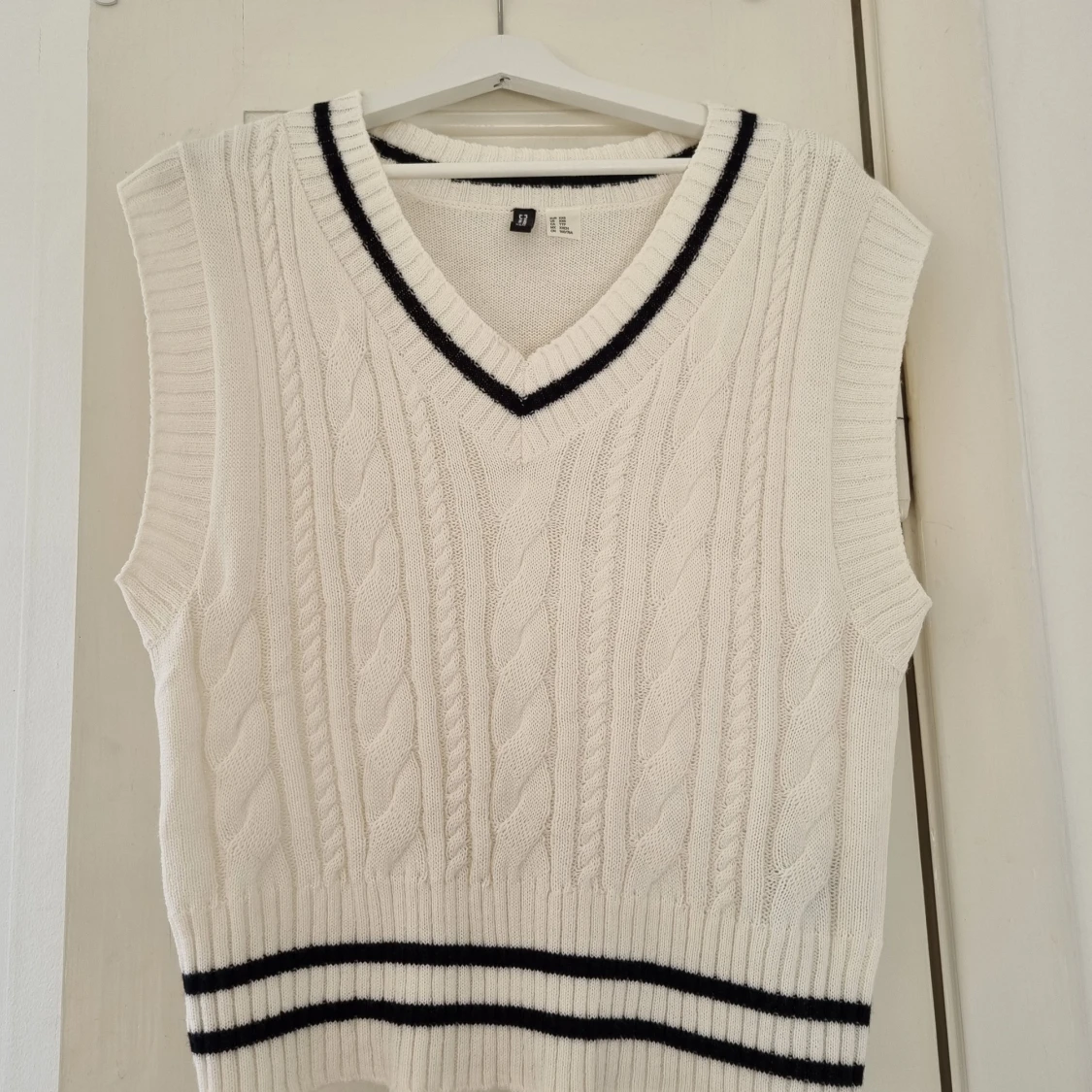 Vit stickad väst med svarta ränder