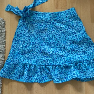Blå blommig kjol💕 - Storlek XXS, jätte fin kjol från new yorker passar inte längre har en drag kedja på sidan den går ner till knäna typ och passar me massa olika färger💕