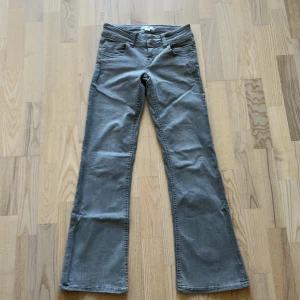 Grå low waist bootcut jeans - Jättesnygga low waist bootcut jeans i grå från Gina. Inga hål eller fläckar och bara använda några få gånger! Köparen står för frakten. Skriv om du har några frågor  Innerbenslängd: 73 cm  Midja rakt över: 34 cm (justerbara resår och stretch)  