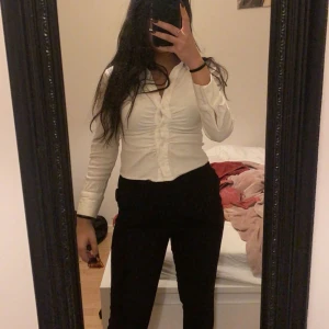 Vit blus med knappar - Säljer en snygg vit blus med knappar framtill. Den är långärmad och har en tight passform som framhäver figuren. Perfekt för både vardag och fest! 💖