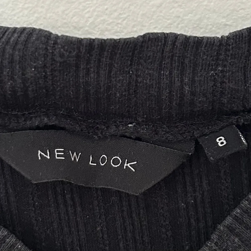 Svart ribbad topp från New Look med halv-polo krage i strl S. Något urtvättad.. T-paidat.